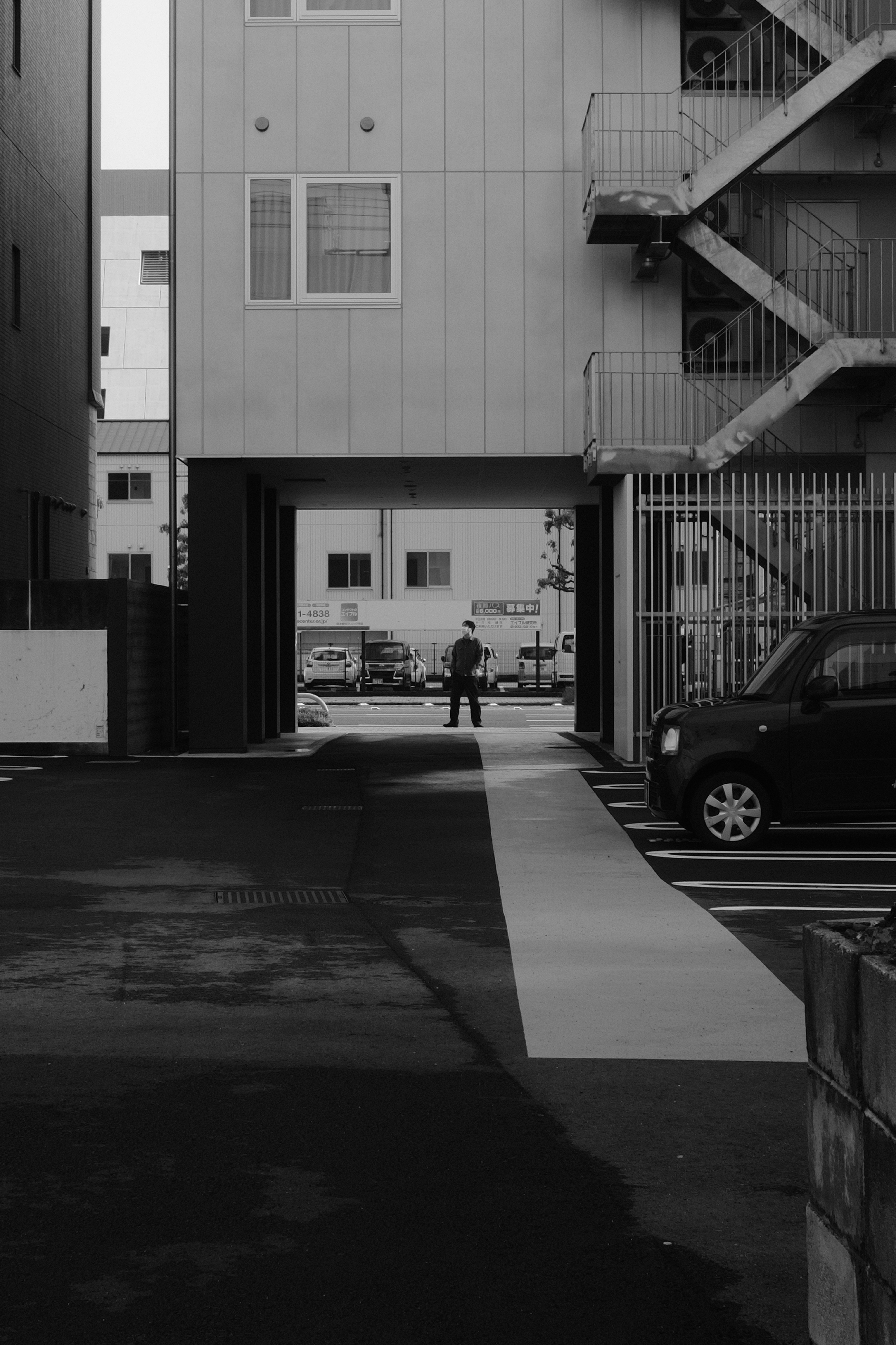 grayscale photo of cars parked in front of building